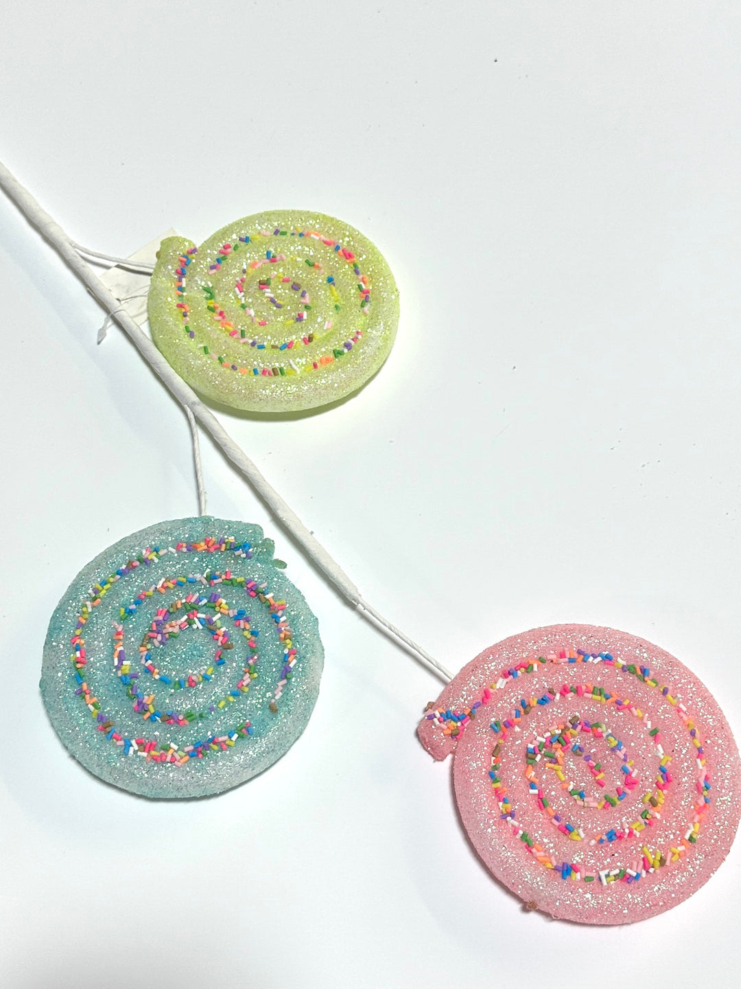 Pink, blue, and yellow lollipops spray with sprinkles