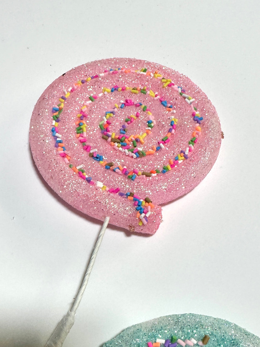 Pink, blue, and yellow lollipops spray with sprinkles