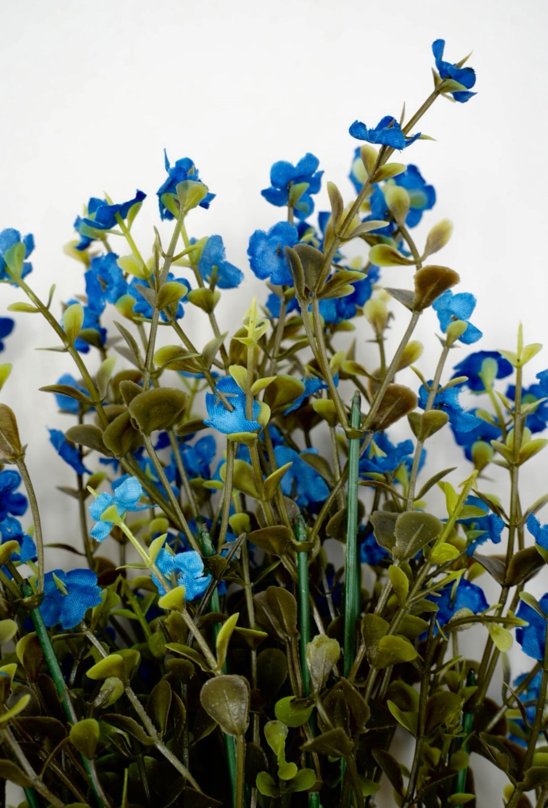 Blue filler flowers and boxwood greenery