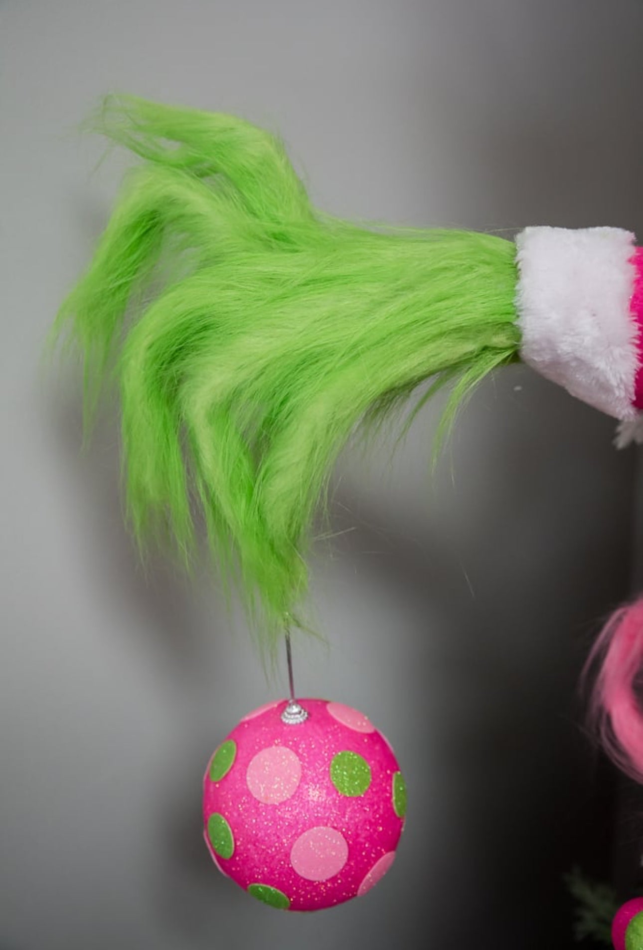 Green fluffy monster hand holding pink ornament - Greenery Market