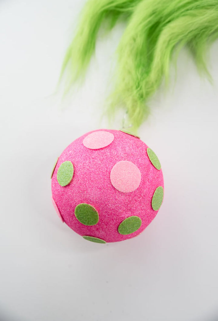 Green fluffy monster hand holding pink ornament - Greenery MarketPicksGM2116PKGN