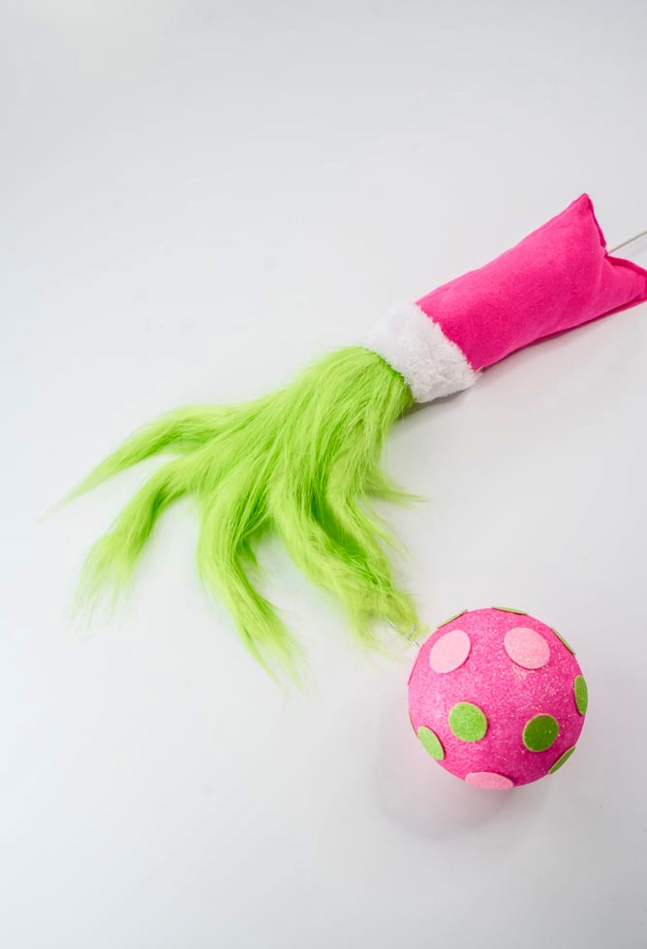 Green fluffy monster hand holding pink ornament - Greenery Market